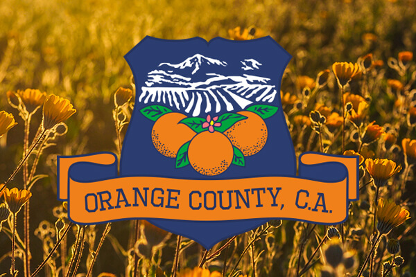 navy blue logo with oranges and mountains and a banner saying orange county, ca