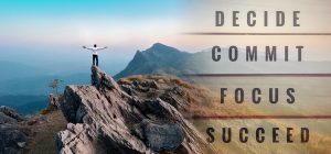 Man standing on mountain looking accomplished with words "decide, commit, focus, succeed" written across