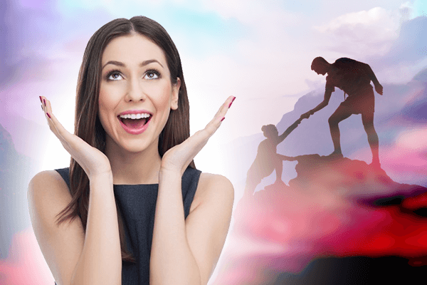 man helping another climb up mountain and woman smiling holding hands around face