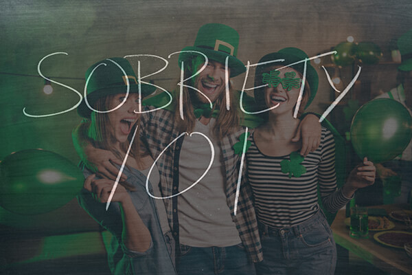 People gathered for St. Patricks day wearing green and laughing with "Sobriety 101" written in thin white letters over photo